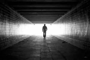 man walking through dark tunnel